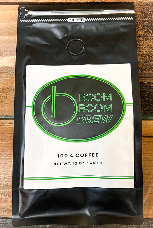 Black coffee packaging with 'Boom Boom Brew' logo on a wooden surface